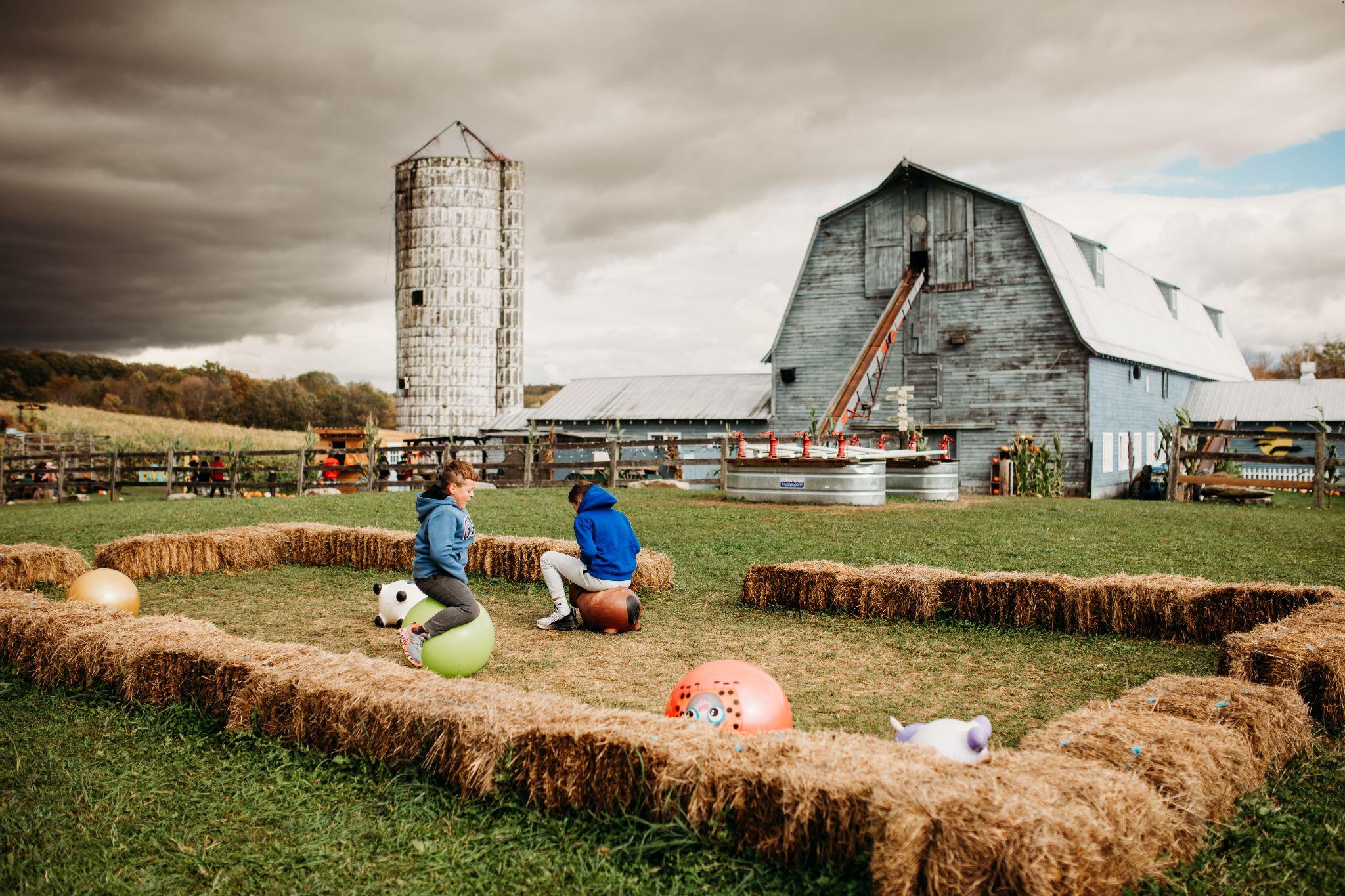 Kids bouncing on hoppity hops inside the hay bale corral